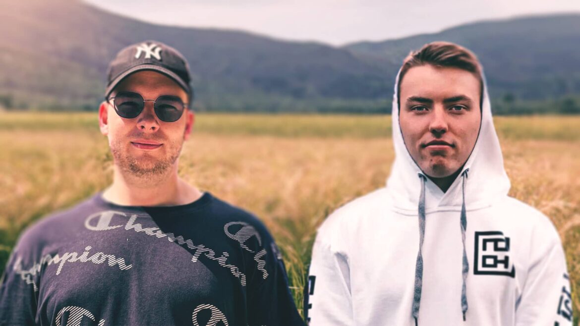 B4ssvibes and NoCheats posing together in a field, wearing casual hoodies and sunglasses, showcasing their cool vibe.