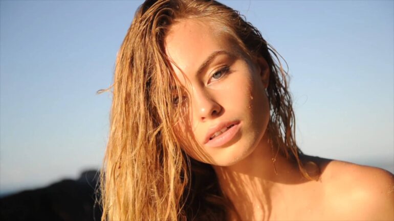 Close-up shot of a model with wet hair, featured in the "Breathe Again" music video.