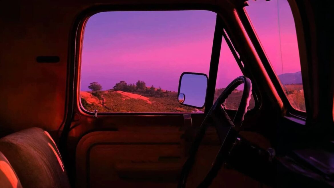 Sunset view through a vintage car window, cover art for "Wake It Up" by Yaroslav Tretiak.