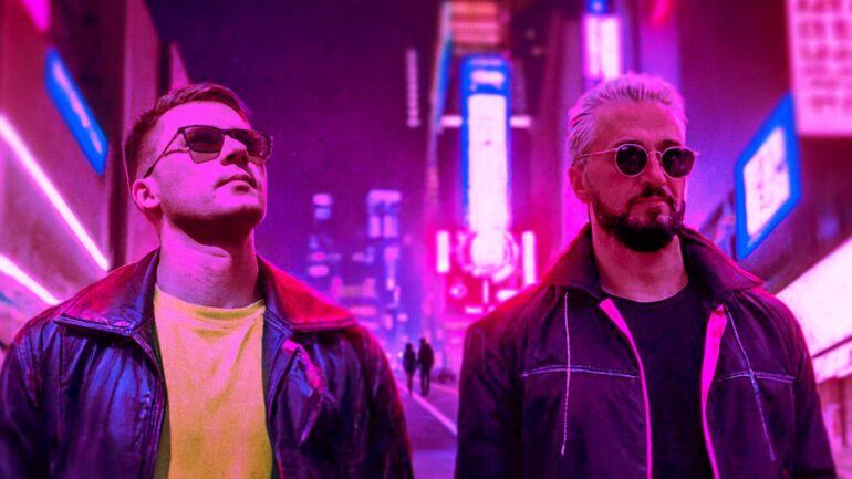 Gorbunoff & Caboo standing in neon cityscape with futuristic vibes.